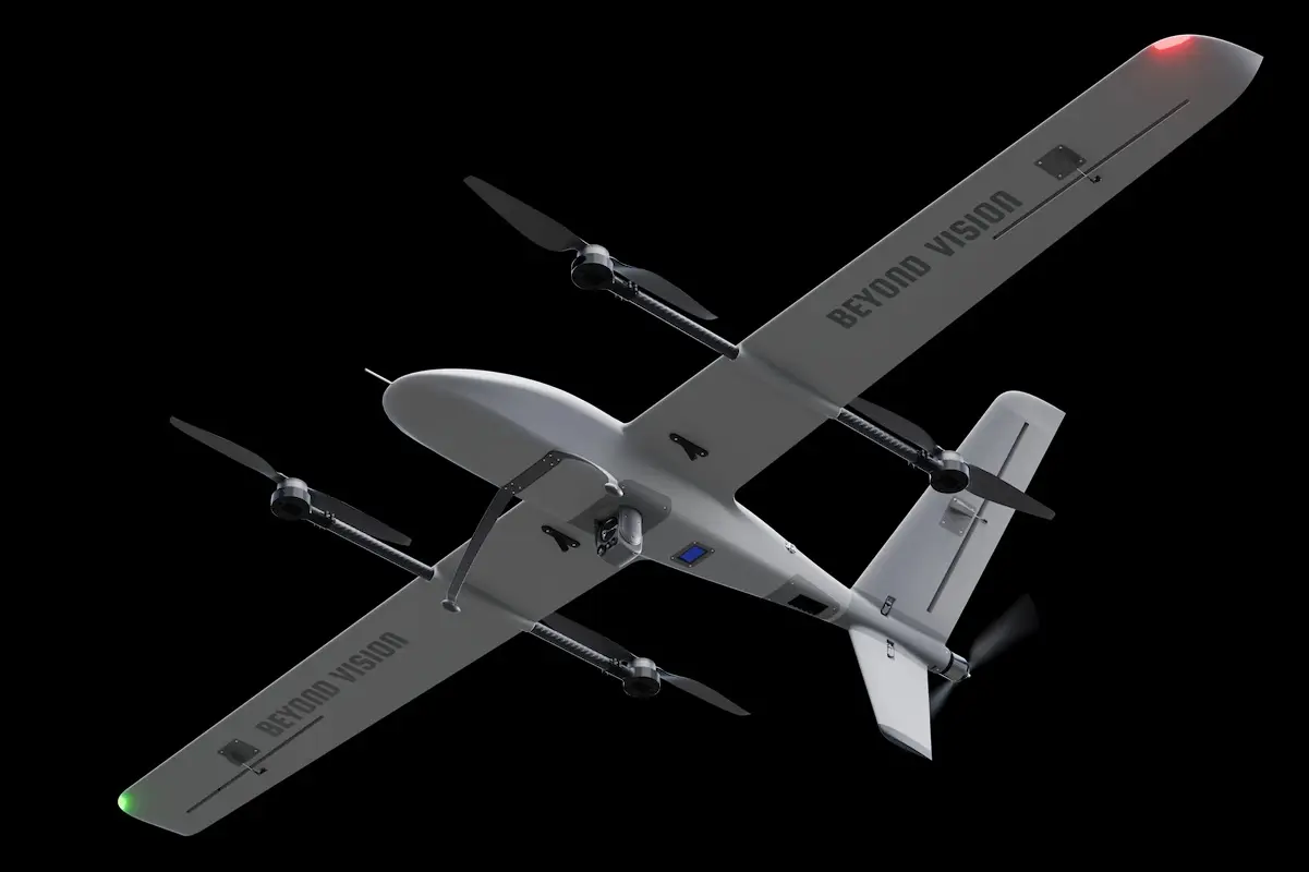 Gray fixed wing drone with four propellers and BEYOND VISION on the wings against a black background
