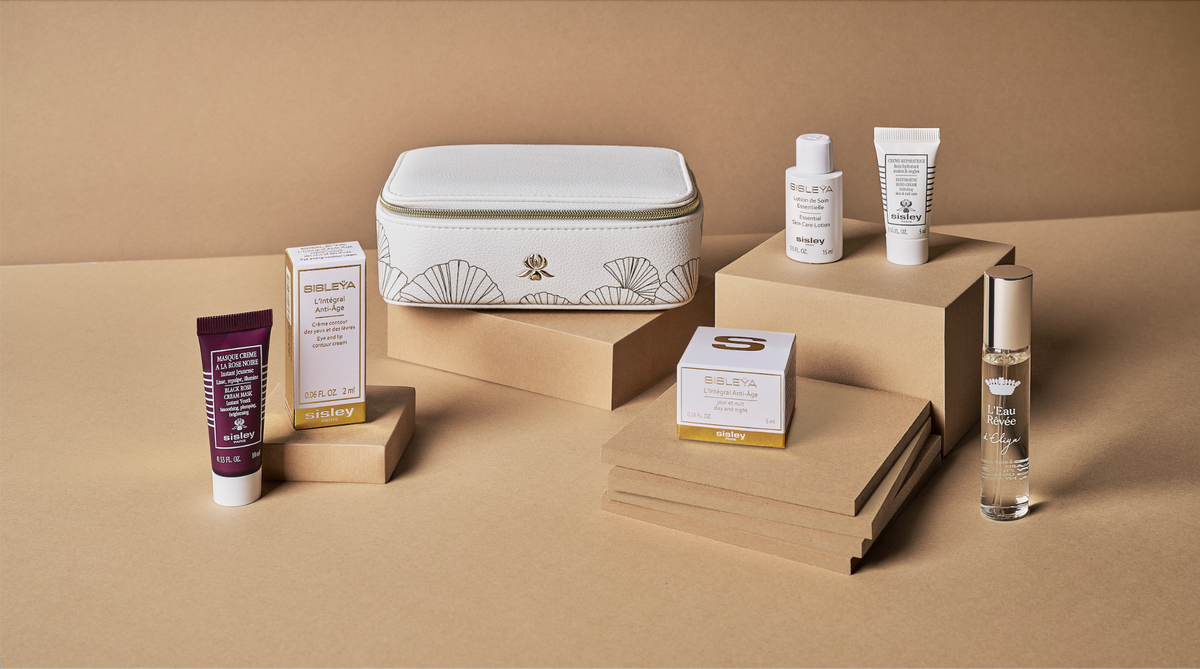 image Assorted Sisley skincare products and a white patterned cosmetic bag on a brown cardboard background arranged on stacked boxes
