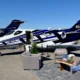 Private jet on a tarmac with its door open set up for a lounge area with couches and a man relaxing nearby