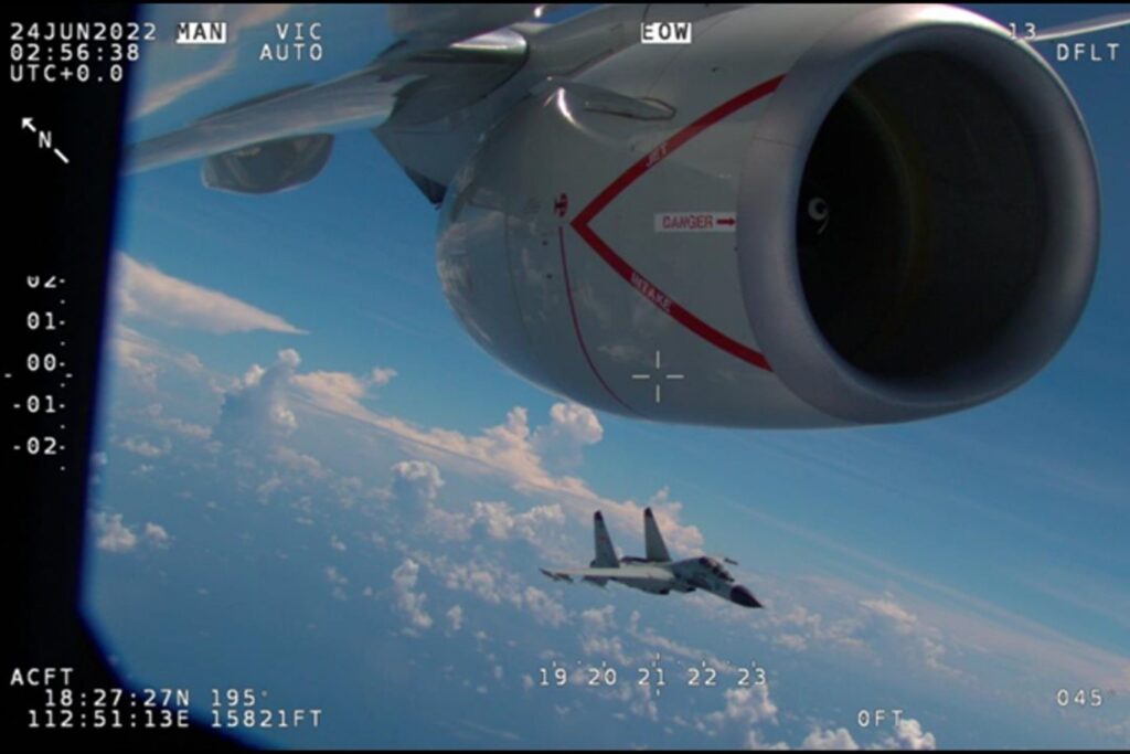 A Chinese fighter flying close to the nacelle of a US aircraft A Chinese fighter flying close to the nacelle of a US aircraft
