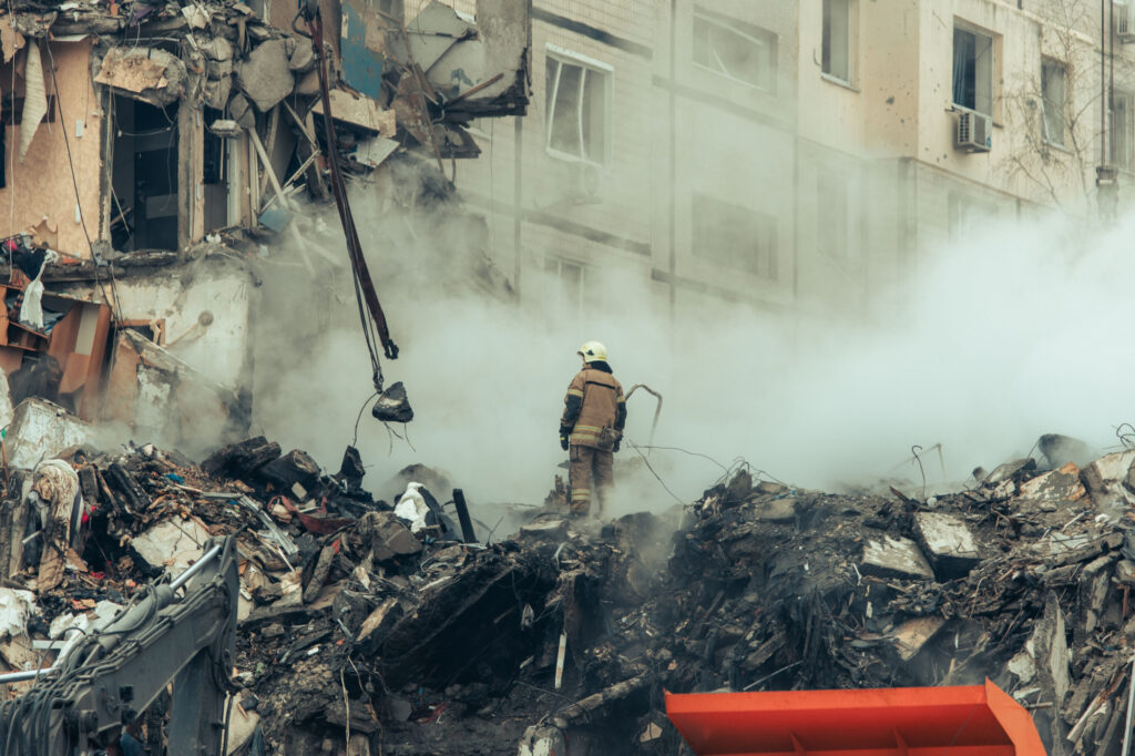 A firefighter standing in the ruins of a residential building in Dnipro
