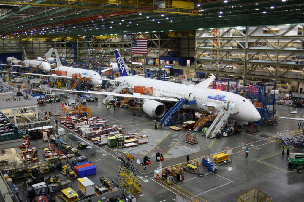 Unidentified Boeing employees continue work building a Boeing 787 jets at its Everett factory