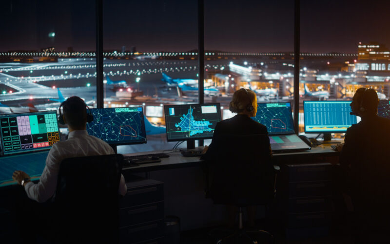 Diverse Air Traffic Control Team Working in Modern Airport Tower at Night