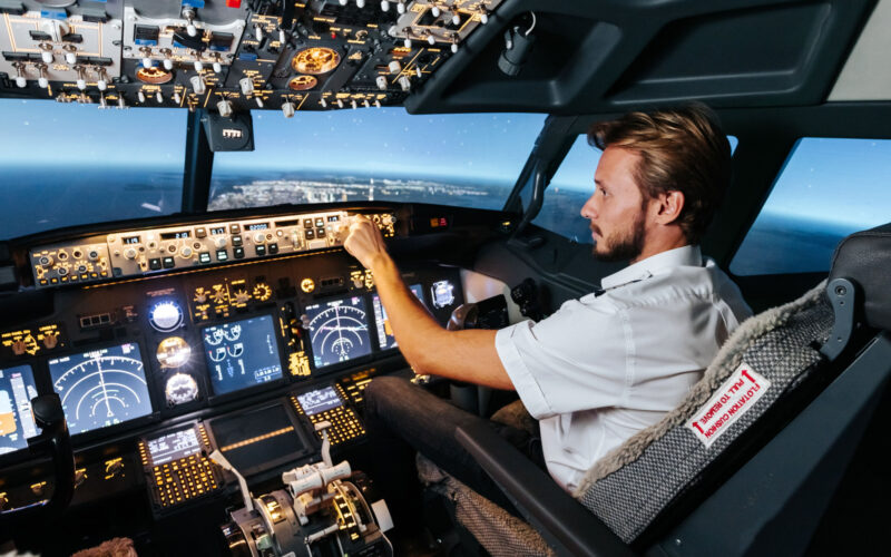 First officer is controlling autopilot and parameters for safety flight. Cockpit of Boeing aircraft.