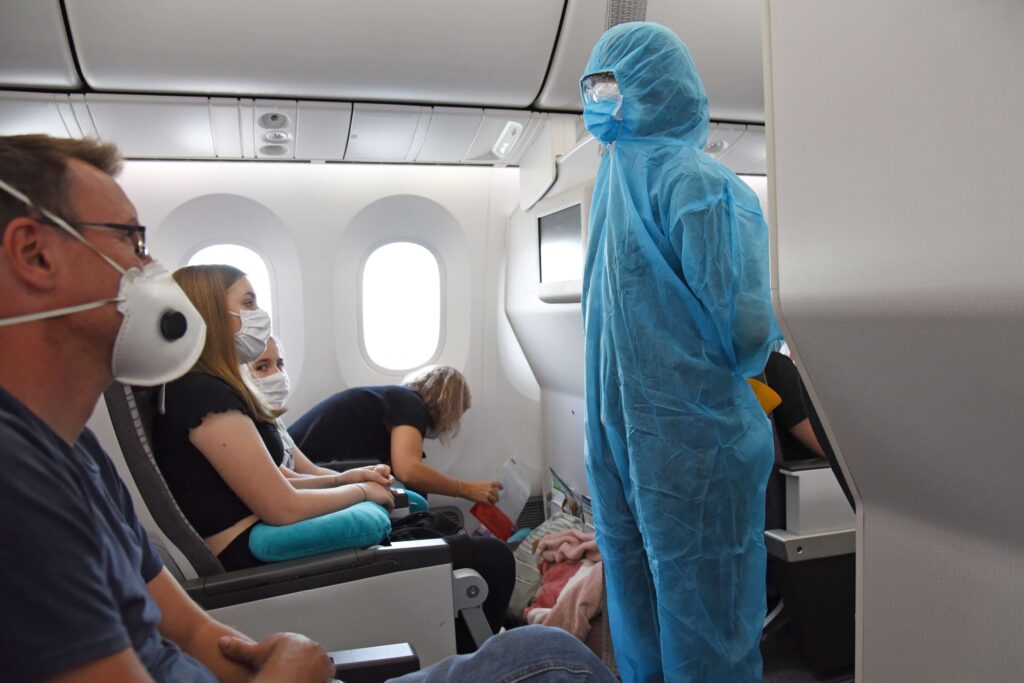 air stewardess crew member prepares to conduct the safety briefing for passengers on board a charter flight wearing full ppe hazmat suit during the corona pandemic 5jpg air_stewardess_crew_member_prepares_to_conduct_the_safety_briefing_for_passengers_on_board_a_charter_flight_wearing_full_ppe_hazmat_suit_during_the_corona_pandemic-5.jpg