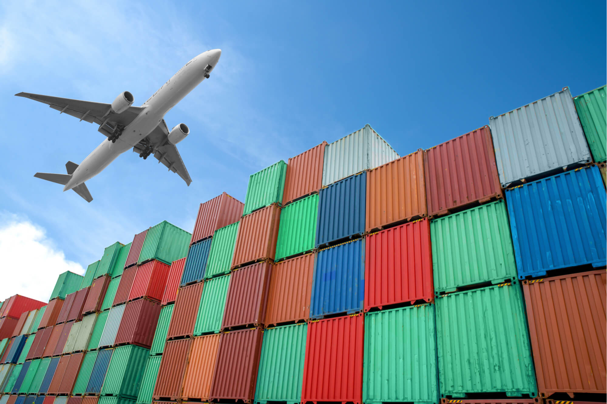 aircraft_flies_over_cargo_containers.jpg