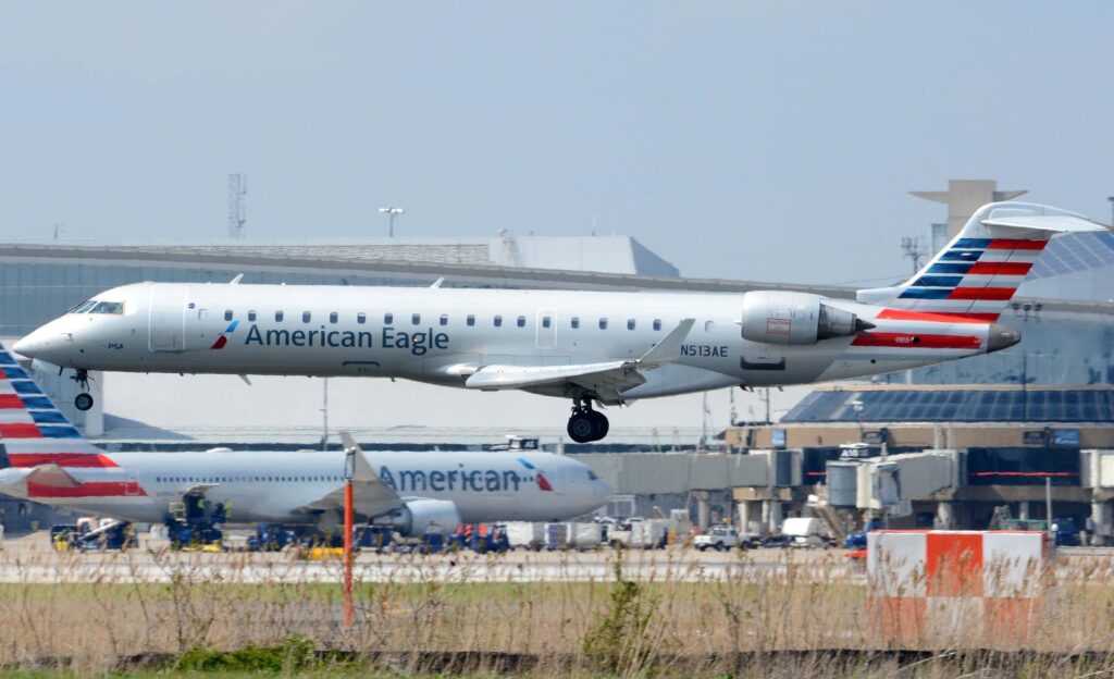 an_american_eagle_crj700_operated_by_psa_airlines_lands_at_philadelphia_international_airport_in_front_of_terminal_a_and_an_american_airlines_a330philadelphia_pa_-_april_28th_2018-min.jpg