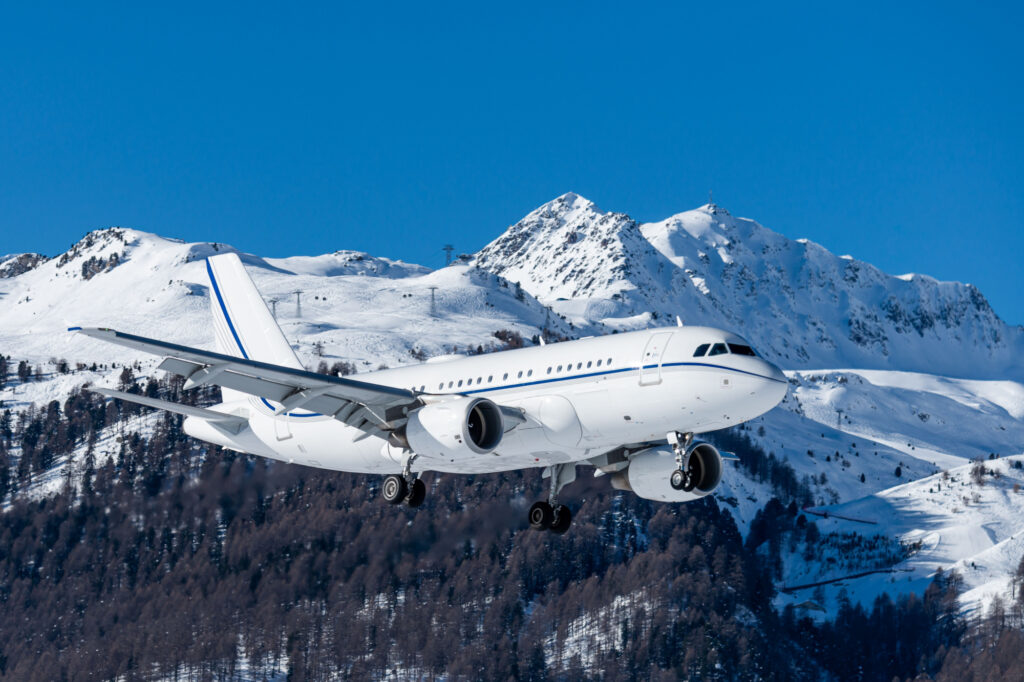 huge private jet (airliners size) arriving at the highest airport in europe with a beautiful mountain scenery in the background