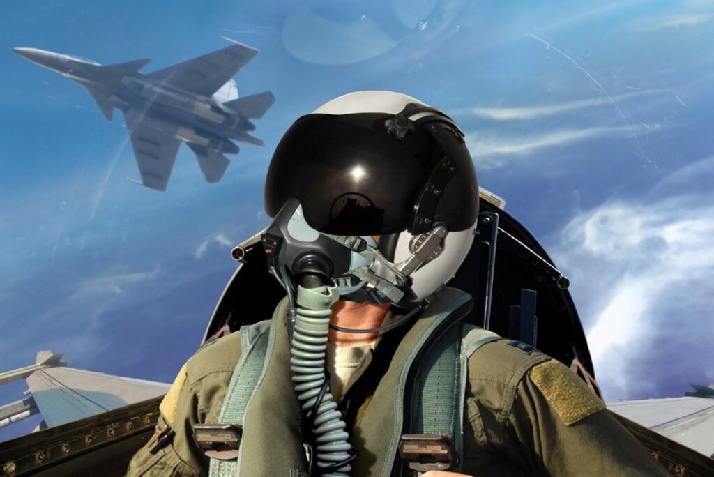 fighter pilot in a cockpit looking up in the sky