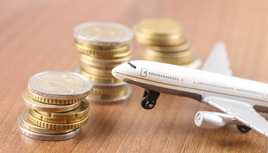 white plane model next to the coins all placed on a table