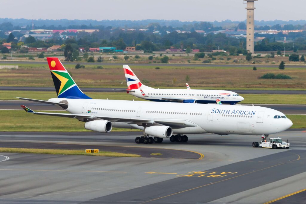 johannesburg__south_africa_march_30_2019_south_african_airways_airbus_a340_and_british_airways_comair_boeing_737_at_o._r._tambo_international_airport._domestic_market_share_competition..jpg