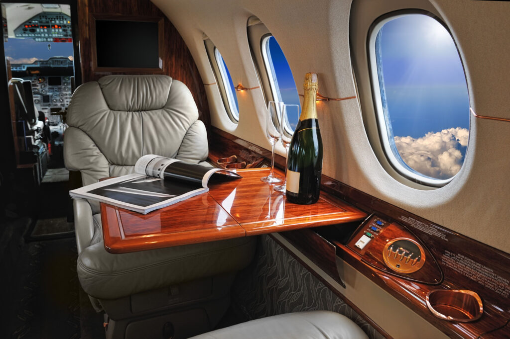 luxury interior in the modern business jet and sunlight at the window/sky and clouds through the porthole