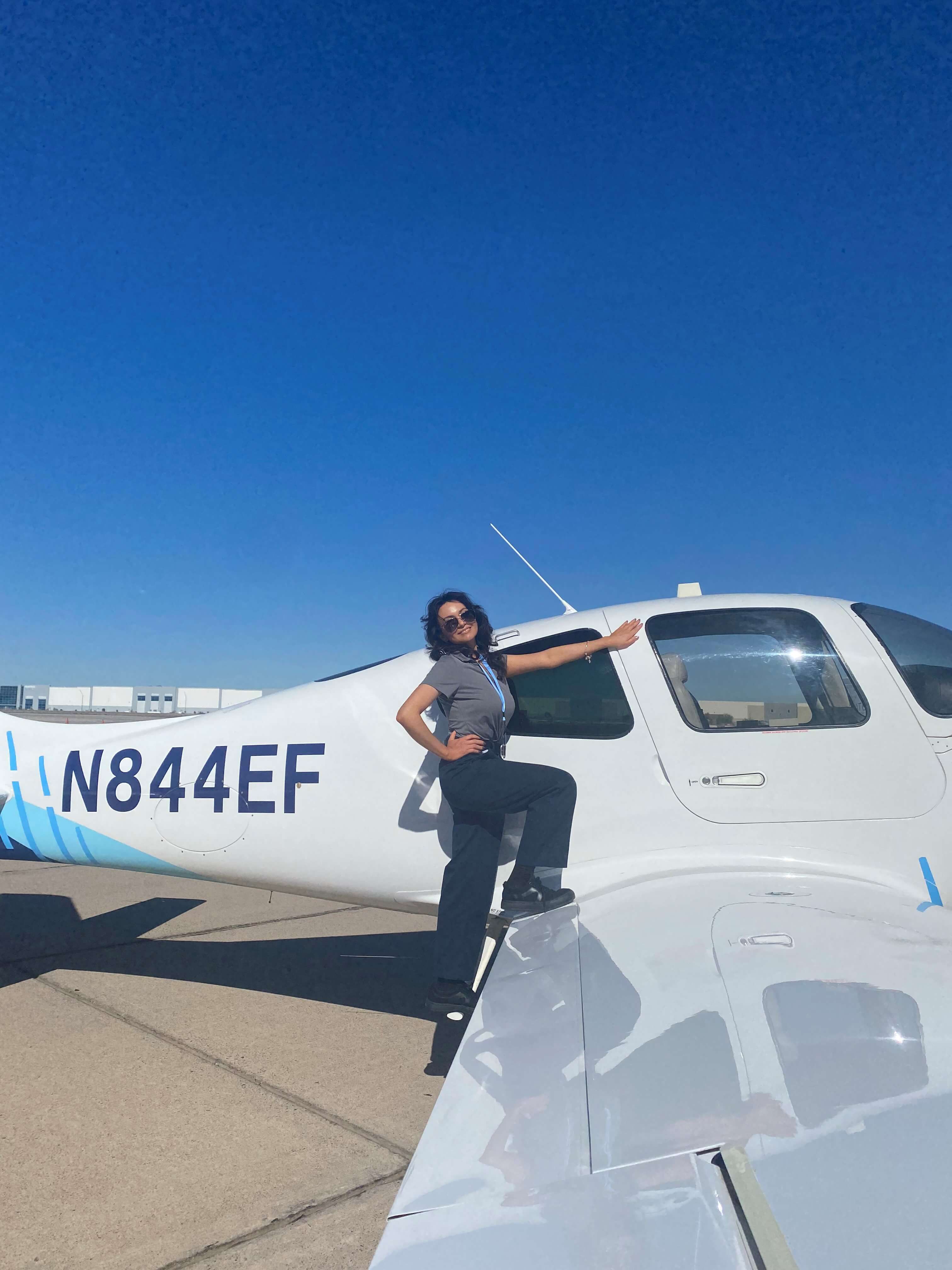 Natalie from the United Aviate Academy poses by a training aircra