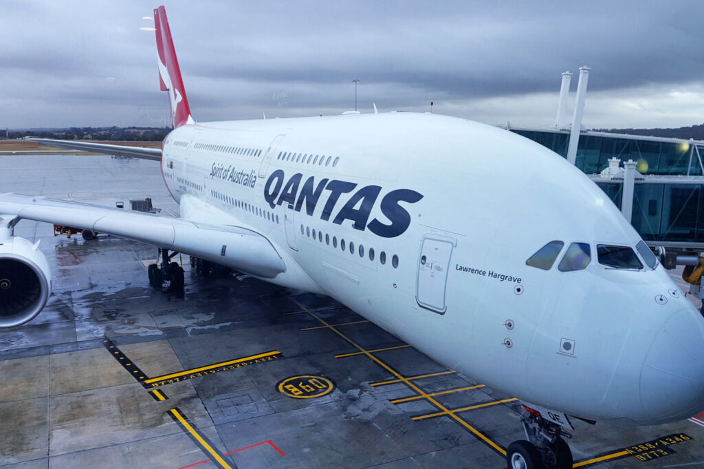 Qantas aircraft waiting for passengers during rainy day at Melbourne international airport.