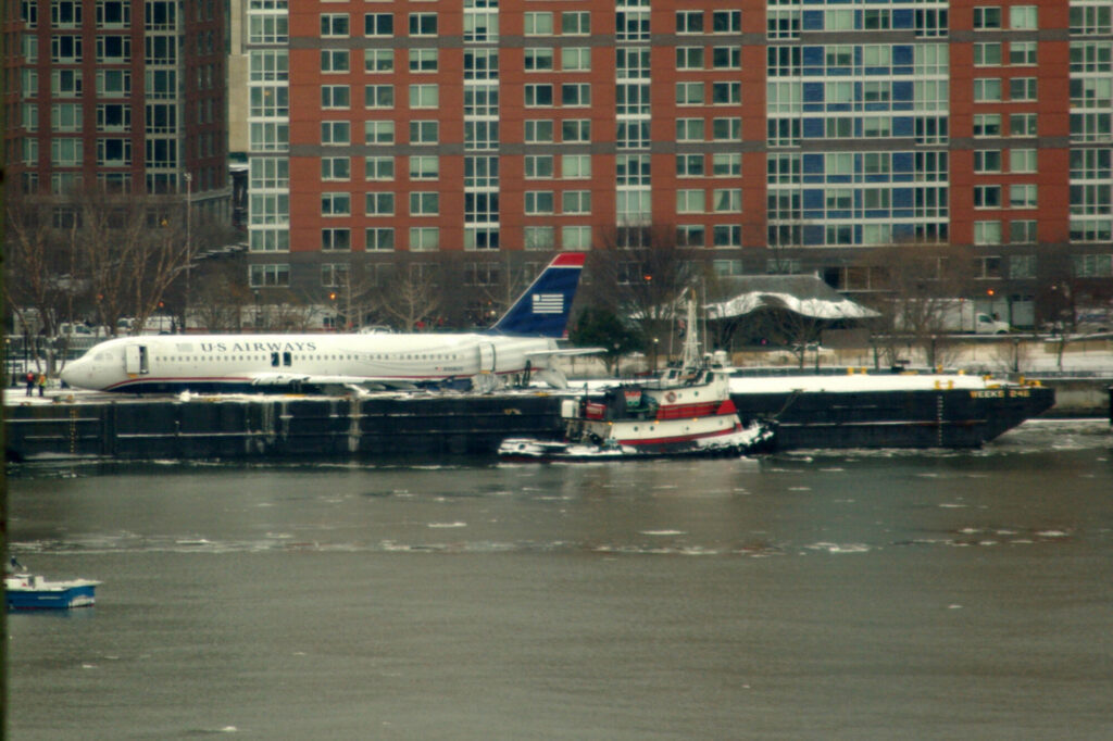 US Airways Flight 1549 resting on a barge next to Battery Park City, after being raised out of the Hudson River.