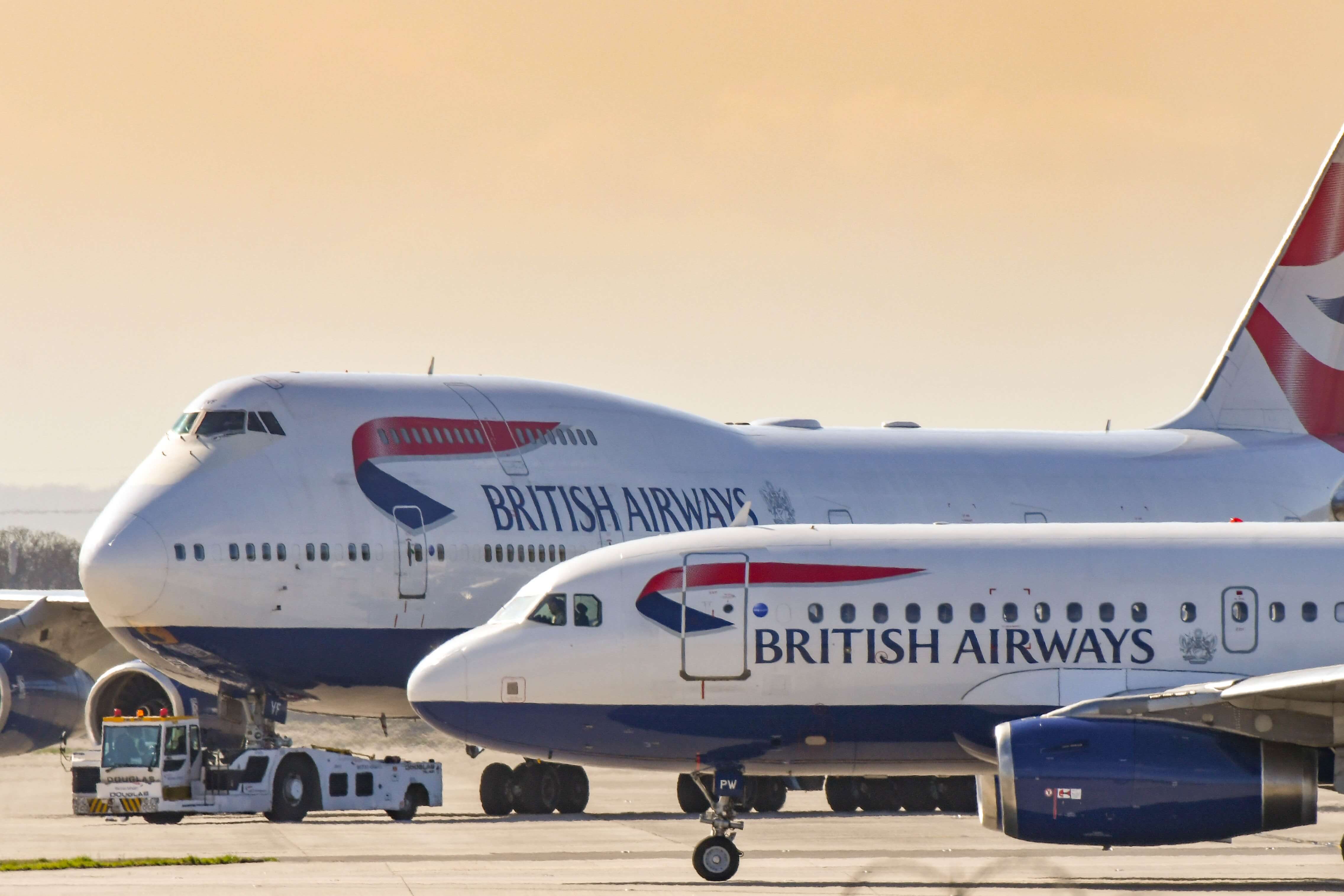 British Airways Airbus A319 jet taxiing past one of the airline's