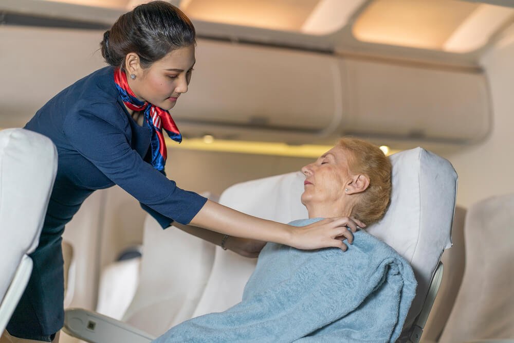 Flight attendant takes care of a passenger